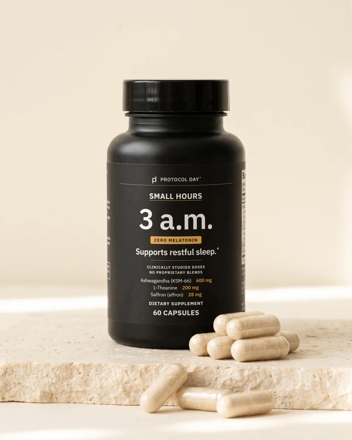 Small Hours bottle with capsules on a stone surface.