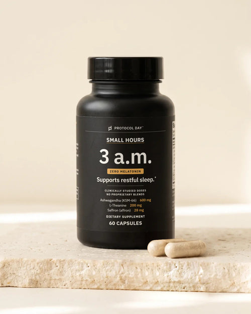 Small Hours bottle with capsules on a stone surface.