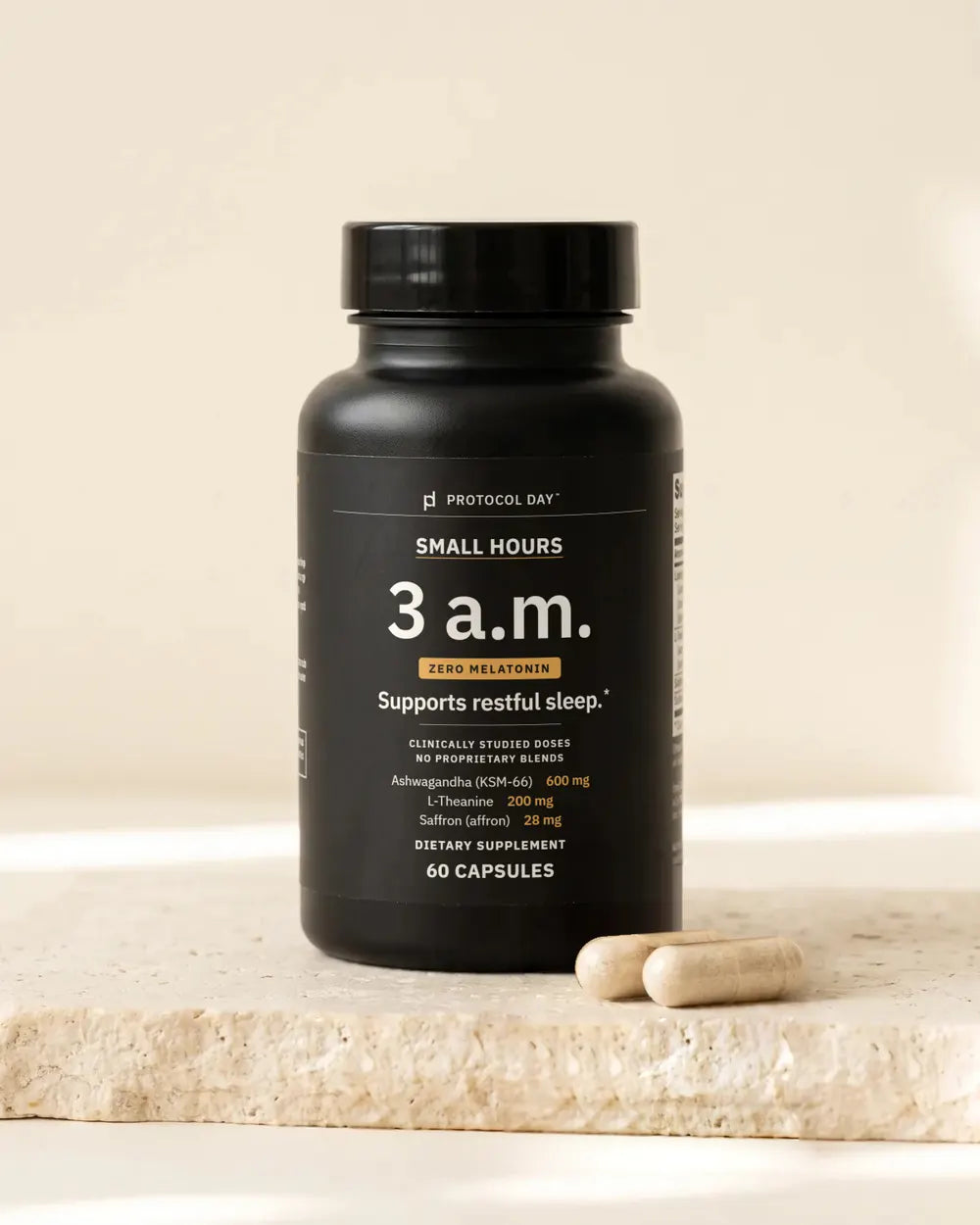 Small Hours bottle with capsules on a stone surface.